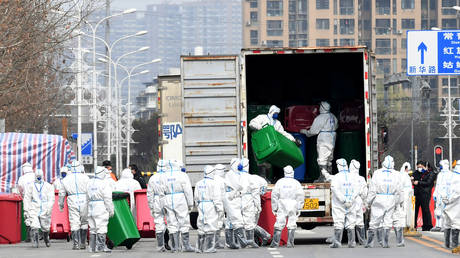 FILE PHOTO. Workers in protective suits take part in the disinfection of Huanan seafood market in Wuhan, China.