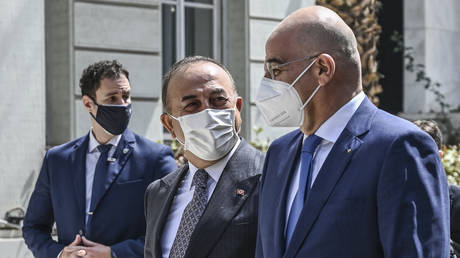 Turkish Foreign Minister Mevlut Cavusoglu (C) and Greek Foreign Minister Nikos Dendias (R) in Athens, Greece, May 31, 2021. © Aris Messinis/AFP