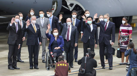 Taiwan's Foreign Minister Joseph Wu, fourth from right, waves with U.S. senators to his right Democratic Sen. Christopher Coons of Delaware, a member of the Foreign Relations Committee, Democratic Sen. © Pool Photo via AP