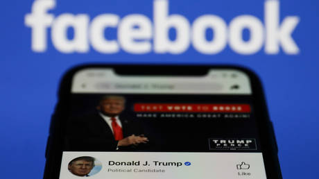 Donald Trump's Facebook account is seen displayed on a phone screen with Facebook logo in the background. © Jakub Porzycki/NurPhoto via Getty Images