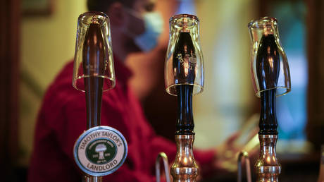 Empty pint glasses sit on the top of beer pumps of the Peveril Of The Peak pub signifying they have been disconnected from the barrels ahead of new Tier-3 Covid-19 restrictions on October 22, 2020 in Manchester, England. © Christopher Furlong/Getty Images