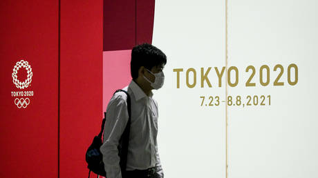 A man walks past a Tokyo 2020 advertising poster at the Shinjuku Metro Station, in Shinjuku area of Tokyo. © Cezary Kowalski/SOPA Images/LightRocket via Getty Images