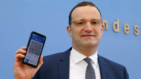 German Health Minister Jens Spahn holds up a mobile phone displaying a QR code as he attends a news conference in Berlin, Germany on June 10, 2021.