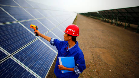 FILE PHOTO: A worker inspects solar panels at a solar farm in Dunhuang, 950km (590 miles) northwest of Lanzhou, Gansu Province, China