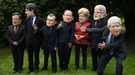 Extinction Rebellion environmental activists wear headgear depicting the G7 leaders as they demonstrate during the G7 summit Cornwall on June 12, 2021.