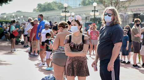 FILE PHOTO. Guests wearing protective masks wait outside the Magic Kingdom theme park at Walt Disney World on the first day of reopening, in Orlando, Florida. © AFP / Gregg Newton.