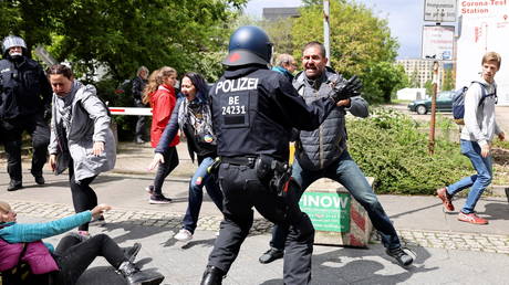 A police officer confronts a demonstrator during a protest against the government measures to curb the spread of the coronavirus disease (Covid-19), in Berlin, Germany, (FILE PHOTO) © REUTERS/Christian Mang