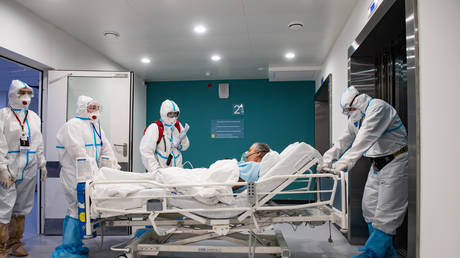 Medical specialists wearing protective gear transport a patient at the City Hospital Number 40, where patients suffering from the coronavirus disease are treated, in Kommunarka settlement in the south of Moscow, Russia.