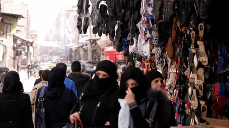 Women walk at a market in Douma, in the eastern suburbs of Damascus, Syria March 10, 2021. Picture taken March 10, 2021. © REUTERS/Omar Sanadiki