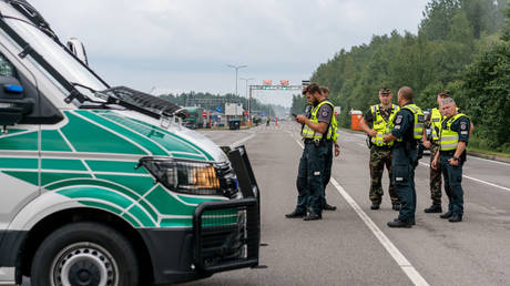 Lithuanian police officers and border guards stand near Belarusian border as a 35 km human chain takes place across cities on August 23, 2020 in Medininkai, Lithuania. © Arturas Morozovas/Getty Images