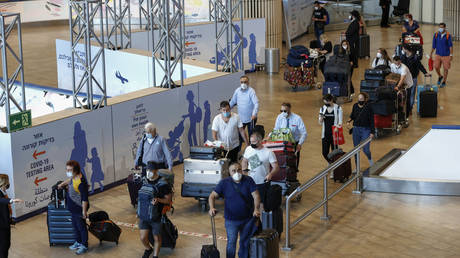 Israelis and vaccinated tourists wearing masks for COVID-19 protection arrive to Israel's Ben Gurion Airport near Tel Aviv on May 23, 2021. © JACK GUEZ / AFP
