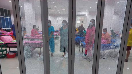 Patients are seen behind a broken glass door after a shooting in a coronavirus (Covid-19) field hospital in Pathum Thani, Thailand June 24, 2021 © Dailynews via REUTERS