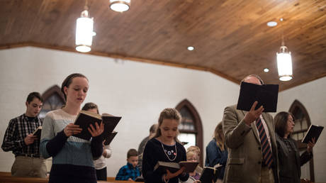 FILE PHOTO: People sing hymns at Grace Orthodox Presbyterian Church during a Sunday evening service in Lynchburg, Virginia. © Nicholas Kamm / AFP