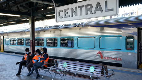 Transport workers sit together on an empty train platform in Sydney, Australia, June 26, 2021.