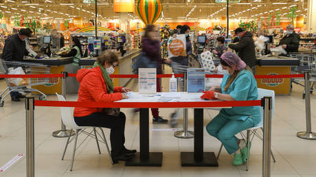 A woman fills in a form before receiving a dose of with Russian Gam-COVID-VAK (trademark "Sputnik V") coronavirus vaccine at a vaccination point at a Globus hypermarket, in Moscow, Russia.