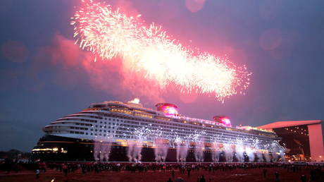 FILE PHOTO: People watch the 'float out' of the newly built cruise ship 'Disney Dream' as it leaves the covered building dock at the Meyer shipyard in Papenburg, Germany.