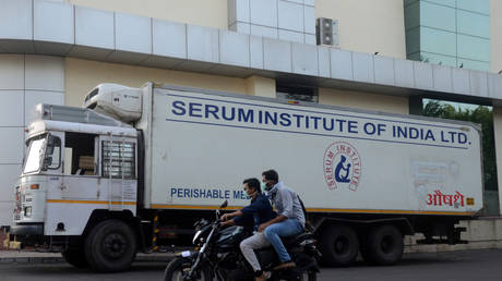 Men ride on a motorbike past a supply truck of India's Serum Institute, the world's largest maker of vaccines, which is working on a vaccine against the coronavirus disease (Covid-19) in Pune, India, (FILE PHOTO) © REUTERS/Euan Rocha