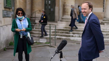 Matt Hancock smiles during a television interview as his aide Gina Coladangelo looks on, outside BBC's Broadcasting House in London