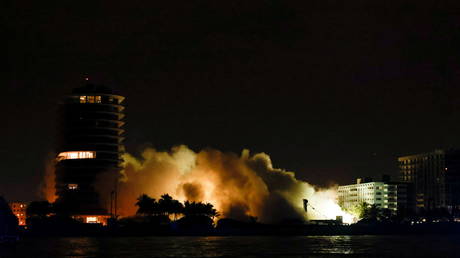 Smoke is seen after the partially collapsed Champlain Towers South residential building is demolished, in Surfside, Florida, U.S., July 4, 2021. © REUTERS/Marco Bello