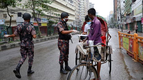 Members of Border Guard Bangladesh (BGB) check commuters at a checkpost during a countrywide lockdown in Dhaka, Bangladesh, July 1, 2021. © REUTERS/Mohammad Ponir Hossain