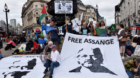 People protest for Julian Assange at Piccadilly Circus on his 50th birthday.