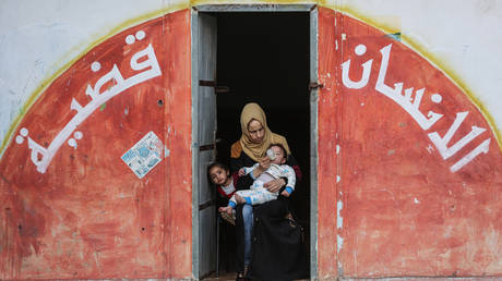 Palestinian families, fleeing from their homes with their belongings, take shelter in a school owned by the United Nations Relief and Works Agency for Palestine Refugees in the Near East. © Ali Jadallah/Anadolu Agency via Getty Images