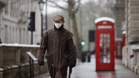 A man wearing a face mask because of the coronavirus pandemic walks in the street in London on February 8, 2021. © Tolga Akmen / AFP
