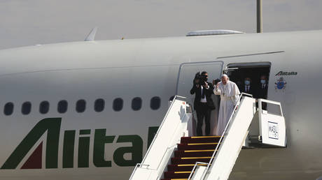 Pope Francis waves to the Iraqi president Barham Salih before boarding his Alitalia Airbus A330 aircraft at Baghdad International Airport as he concludes a four days historical trip around Iraq on March 8, 2021 in Baghdad, Iraq. © Taha Hussein Ali/Getty Images