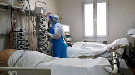 A medical staff member assists a Covid-19 patient at an intensive care department at a hospital in Ariana, Tunisia, April 26, 2021