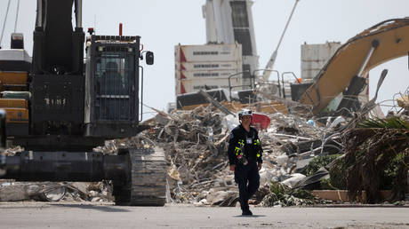 A rescue worker walks away from the remains of the collapsed 12-story Champlain Towers South condo building on July 08, 2021 in Surfside, Florida