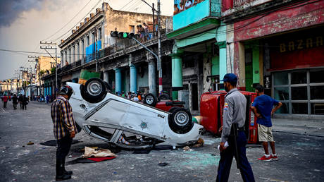 Police cars are seen overturned in the street amid demonstrations against Cuban President Miguel Diaz-Canel in Havana, on July 11, 2021