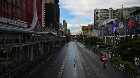 A man crosses the road on Ratchaprasong intersection in Bangkok on July 12, 2021, on the first day of stricter lockdown restrictions to try to contain the spread of the Covid-19 coronavirus. © AFP / Lillian SUWANRUMPHA