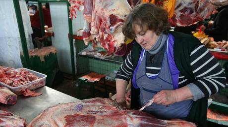 A saleswoman processes meat at a food market in Kiev.