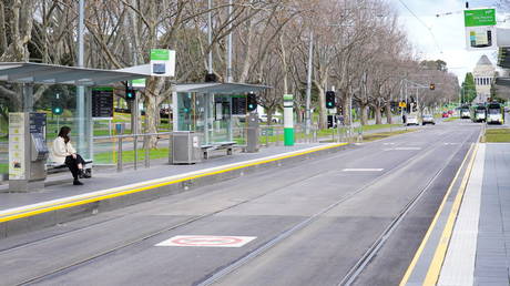 FILE PHOTO. A lone passenger sits at a tram stop in Melbourne, Australia on July 16, 2021.