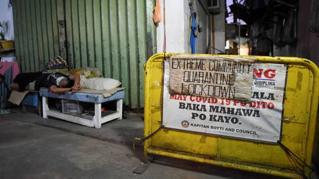 A signage blocks a street where positive and suspected cases of COVID-19 are identified, in a village under local lockdown, in Pasay, Metro Manila, Philippines, February 25, 2021. © REUTERS/Lisa Marie David