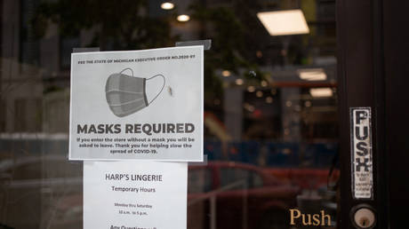 A sign on the door of a store requiring masks to be worn by customers is seen in Birmingham, Michigan, May 27, 2020 Reuters / Emily Elconin