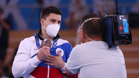 Nagorny shows the bronze medal he won in Tokyo. © Reuters