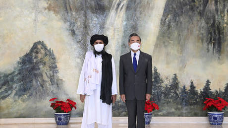 In this photo released by China's Xinhua News Agency, Taliban co-founder Mullah Abdul Ghani Baradar, left, and Chinese Foreign Minister Wang Yi pose for a photo during their meeting in Tianjin, China, Wednesday, July 28, 2021. © Li Ran/Xinhua via AP