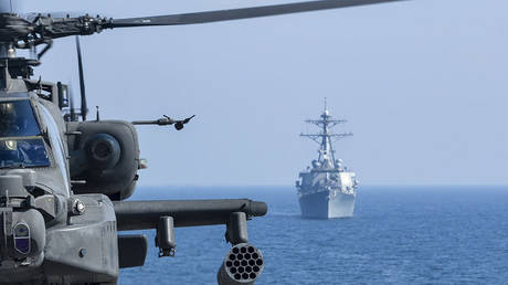 文件照片。一架美国陆军直升机在演习中被看到，导弹驱逐舰 USS Benfold 在附近经过。 © Getty Images / Stocktrek Images