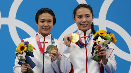 Tingmao Shi and Han Wang of Team China pose with the gold medals on the podium during the medal ceremony for the Women's 3m Springboard Finals on day two of the Tokyo 2020 Olympic Games at Tokyo Aquatics Centre on July 25, 2021 in Tokyo, Japan. © Al Bello/Getty Images