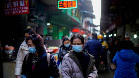 People wearing face masks walk on a street market, following an outbreak of the coronavirus disease (Covid-19) in Wuhan, Hubei province, China (FILE PHOTO) © REUTERS/Aly Song