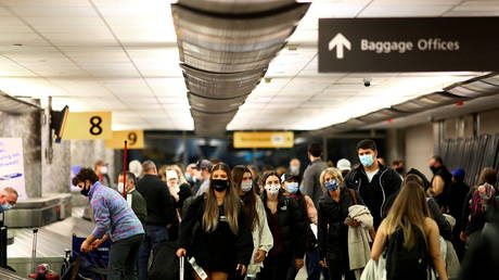 FILE PHOTO: Masked travelers reclaim their luggage at the airport in Denver, Colorado.