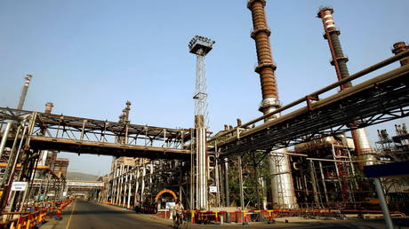 A worker rides a bicycle at the Bharat Petroleum Corporation refinery in Mumbai, India