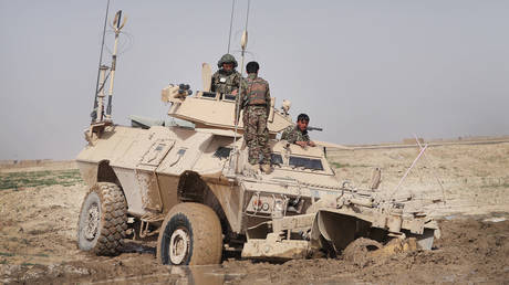 FILE PHOTO. Soldiers from the Afghan National Army try to free their vehicle after it got stuck in mud.