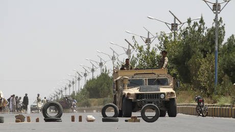 FILE PHOTO. Afghan security personnel patrol along a road on the outskirts of Herat, on August 6, 2021.