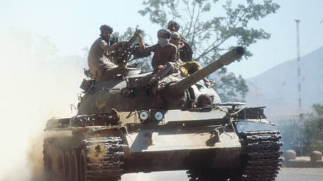 Members of the Taliban army ride atop a tank October 15, 1996 near Kabul, Afghanistan. © Getty Images / Roger Lemoyne / Liaison