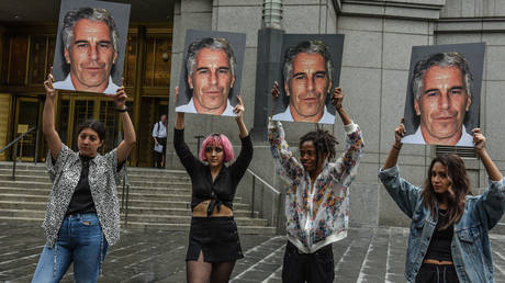 A protest group called 'Hot Mess' hold up signs of Jeffrey Epstein in front of the Metropolitan Correction Center on July 8, 2019 in New York City.