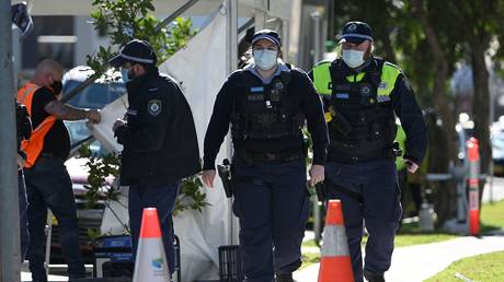 Police officers patrol the streets of Campbelltown, a suburb of Sydney, Australia, August 4, 2021. © Saeed Khan/AFP