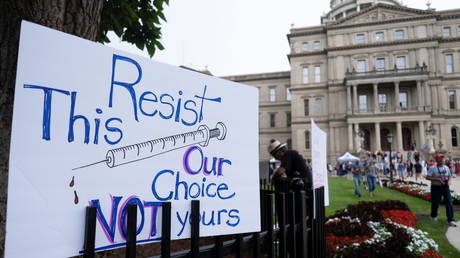 A sign seen at a protest against Covid-19 vaccine mandates outside the Michigan State Capitol building in Lansing, Michigan, US, August 6, 2021. © Reuters/Seth Herald
