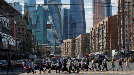 Pedestrians cross the road near the Moscow International Business Center in Moscow, Russia, August 10, 2018.